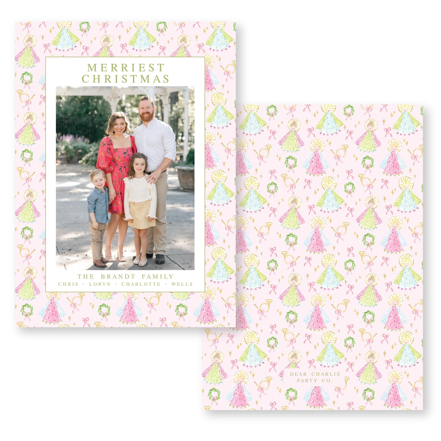 The image is a family portrait of a couple and their two children, taken outdoors in front of a building with a wreath.