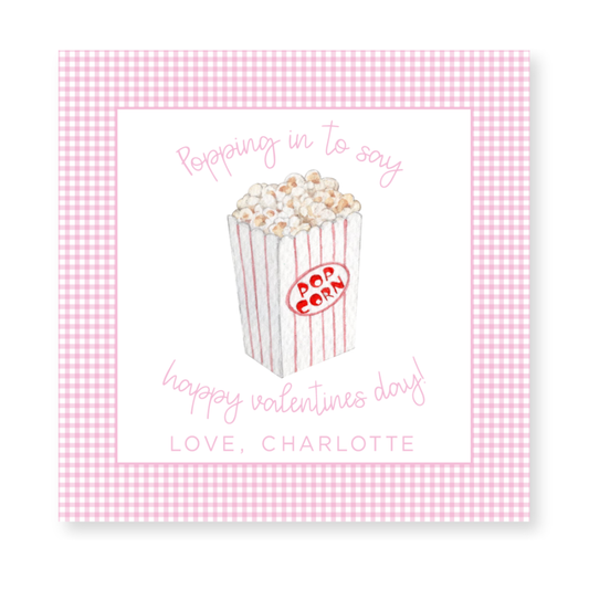 a pink and white checkered card with a popcorn box