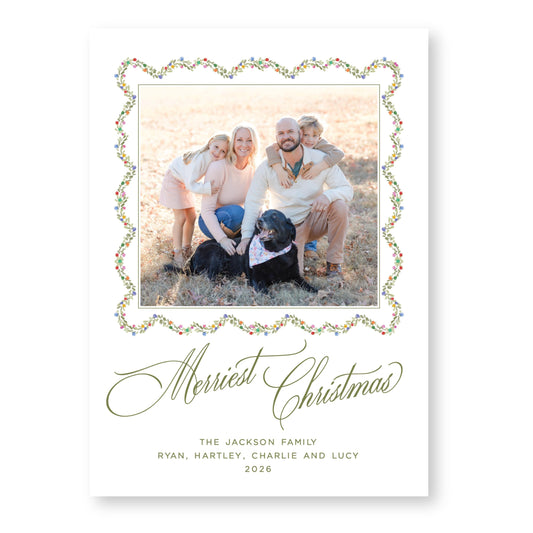 A family portrait of a man, woman, and two children, with a dog in the background, all smiling and posing together. The text at the bottom of the image reads &quot;Merry Christmas THE JACKSON FAMILY RYAN, HARTLEY, CHARLIE AND LUCY 2026&quot;.
