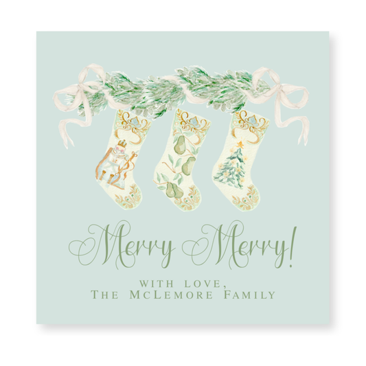a christmas card with three stockings hanging from a tree