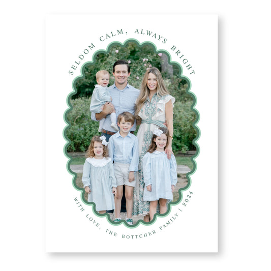 A family portrait of a man, woman, and three children, all dressed in light blue clothing, standing together in a garden setting.