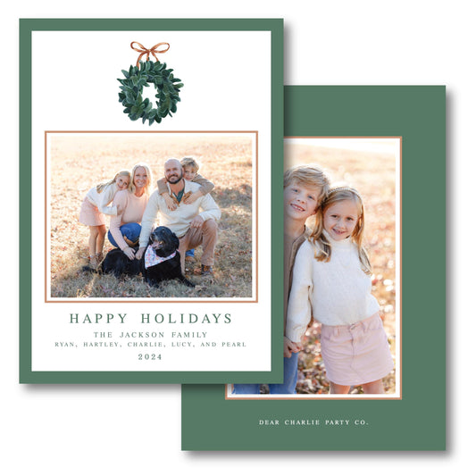 a holiday card with a photo of a family and a wreath