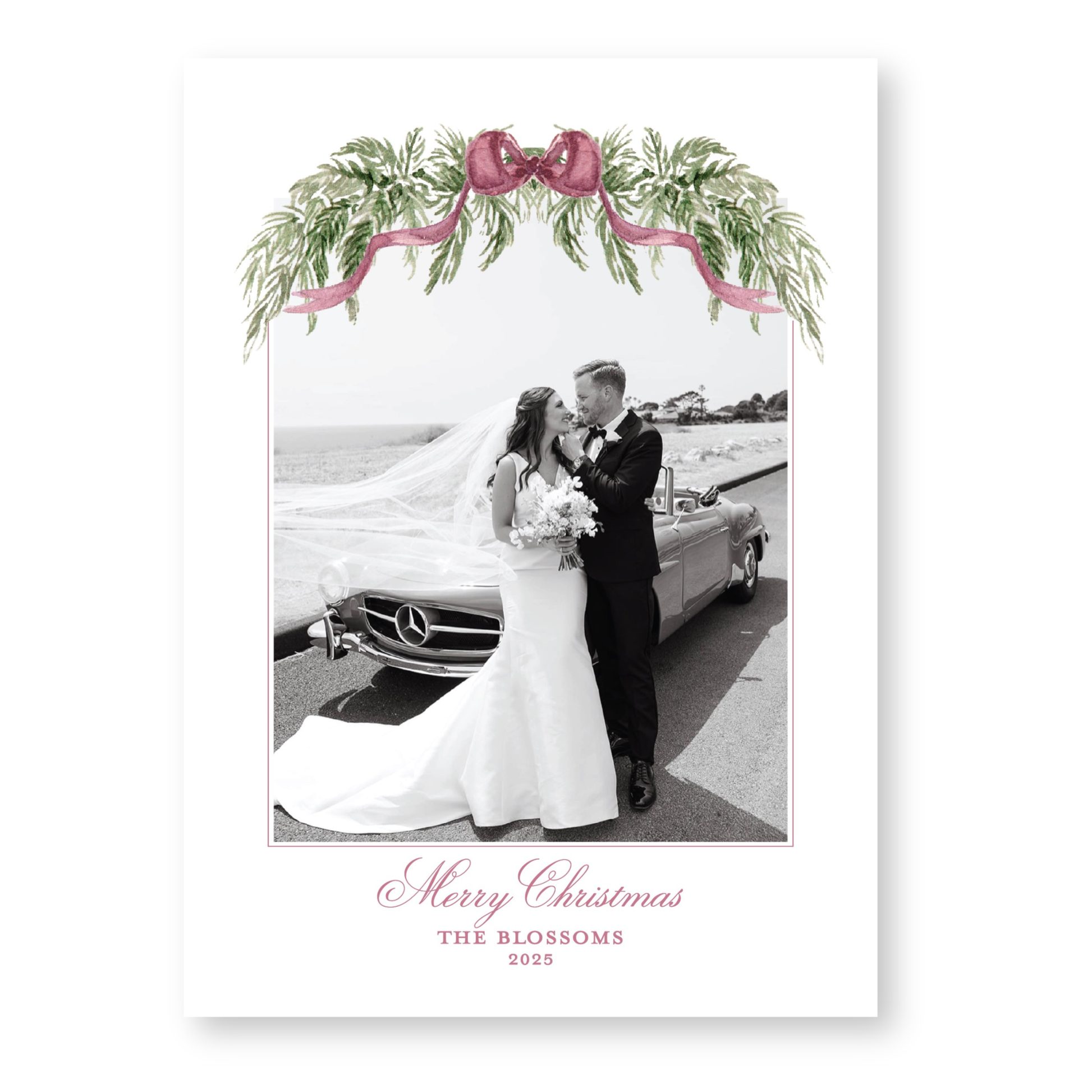 A black and white photograph of a bride and groom standing next to a car, with a floral wreath and ribbon decoration above them. The text at the bottom of the image reads "Merry Christmas THE BLOSSOMS 2015".
