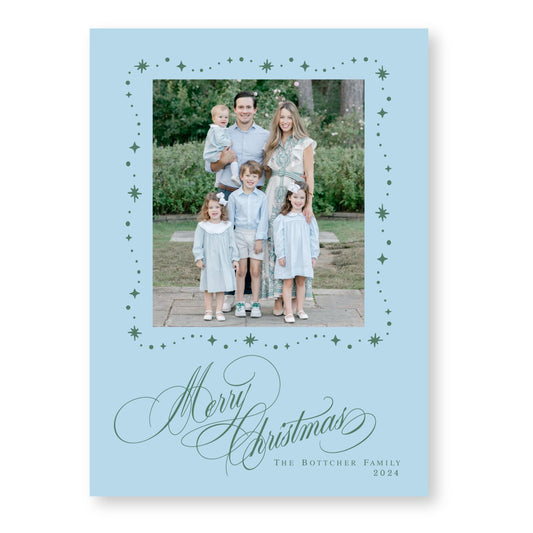 A family portrait of a man, woman, and three children, all dressed in light blue, with a festive &quot;Merry Christmas&quot; greeting at the bottom.