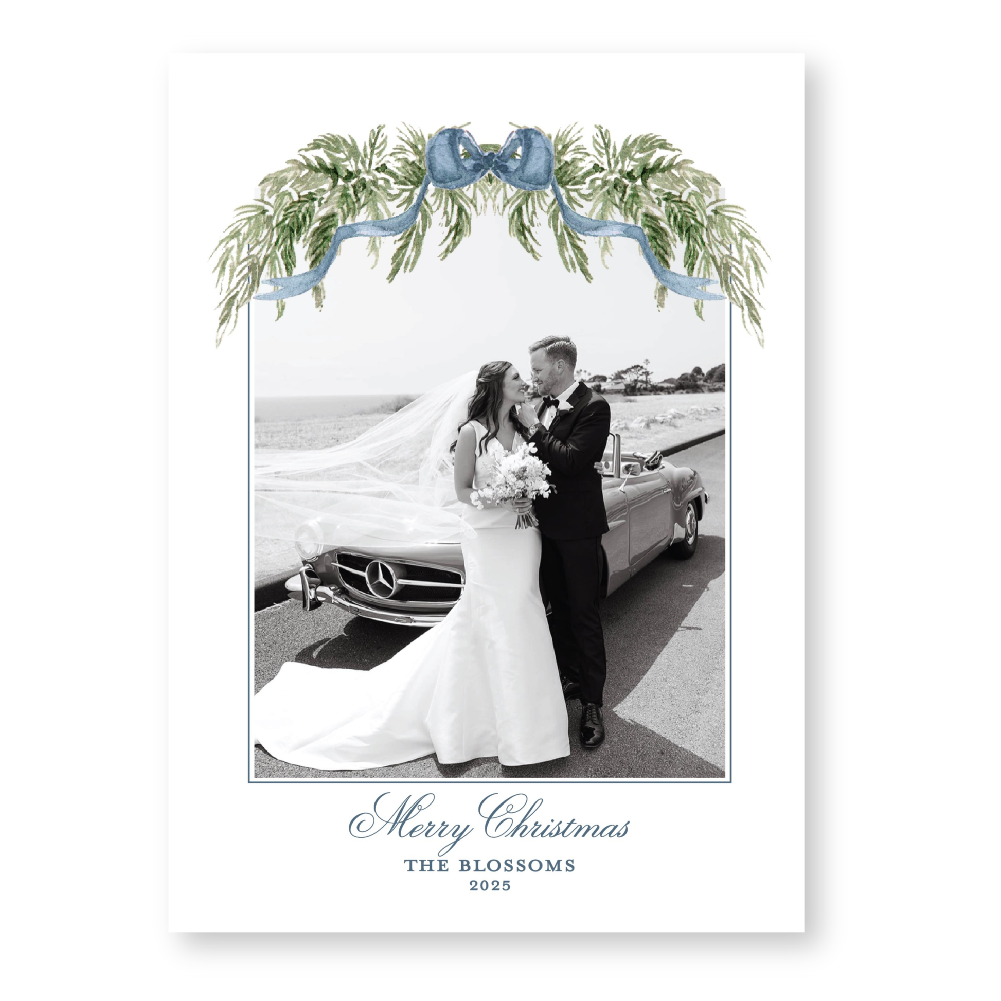 A black and white photograph of a bride and groom standing next to a car, with a decorative floral arch above them. The text at the bottom of the image reads "Merry Christmas THE BLOSSOMS 2028".