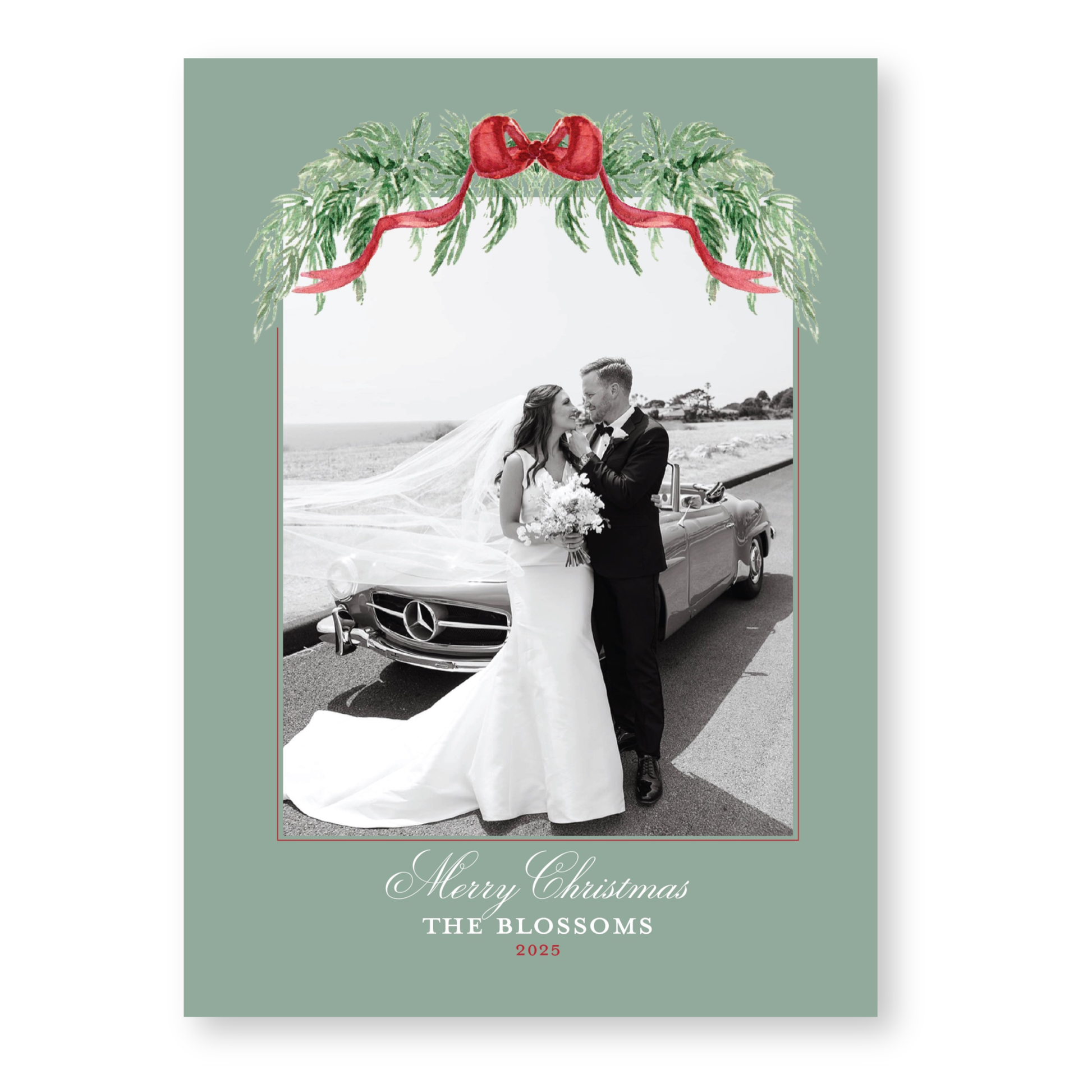 A black and white photograph of a bride and groom standing next to a car, with a festive wreath and red ribbon above them. The text at the bottom of the image reads "Merry Christmas THE BLOSSOMS 2015".