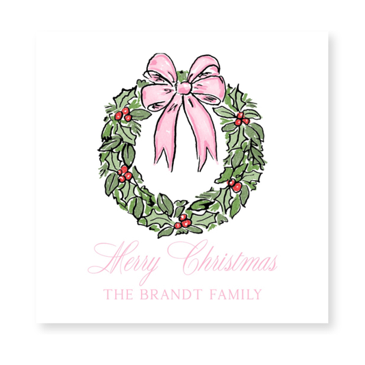 a christmas card with a pink bow and holly wreath