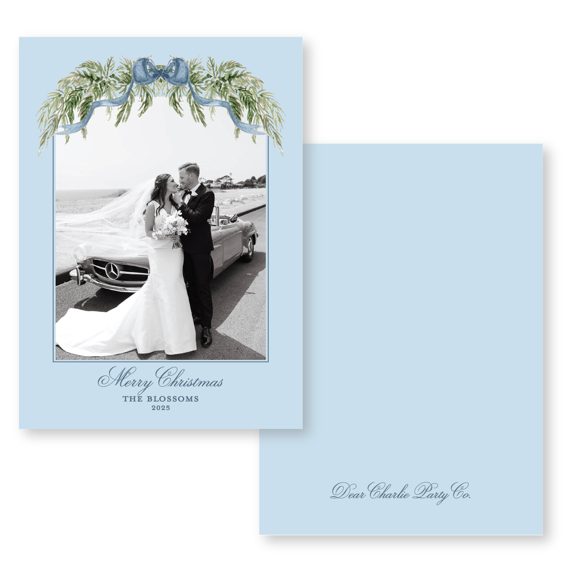 A black and white photograph of a bride and groom standing next to a car, with a floral wreath above them. The text below the image reads "Merry Christmas THE BLOSSOMS 2023 Dear Charlie Party Co."