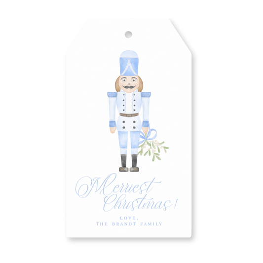 a blue and white christmas gift tag with a nutcracker