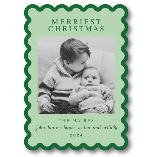 a green christmas card with a picture of a baby holding a baby