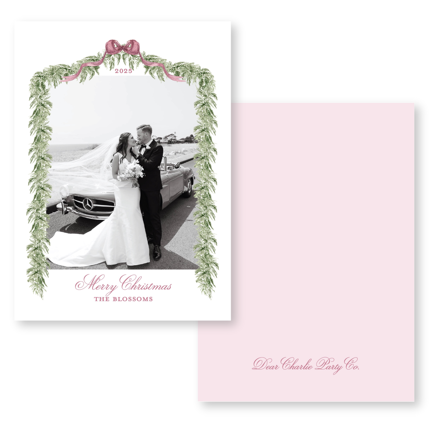 A black and white photograph of a bride and groom standing next to a car, framed by a decorative border with greenery and a pink ribbon. The text on the card reads "Merry Christmas THE BLOSSOMS" and "Dear Charlie Party Co."