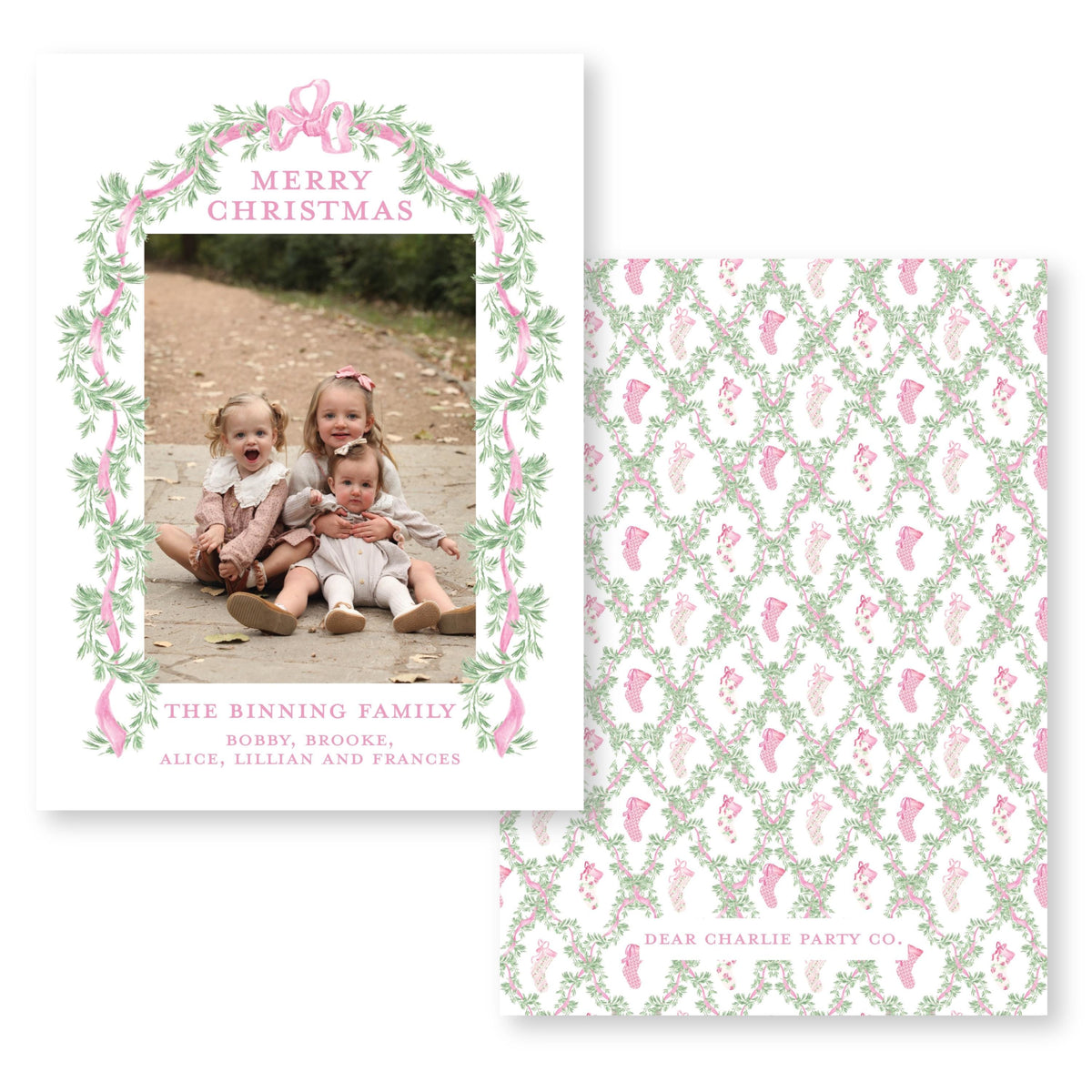 The image is a Christmas card featuring three young girls sitting on a path, surrounded by a floral border and a bow. The card is addressed to "The Binning Family" and includes a photo of the girls.