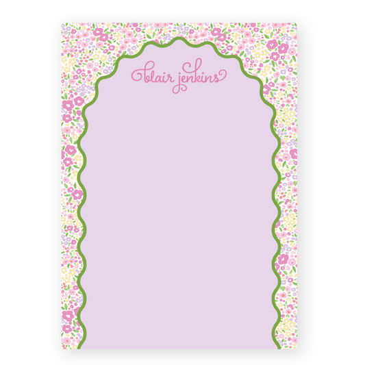 a pink notepad with a floral border