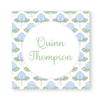 a card with blue flowers and green leaves