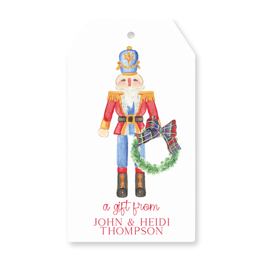 a gift tag with a watercolor nutcracker holding a wreath