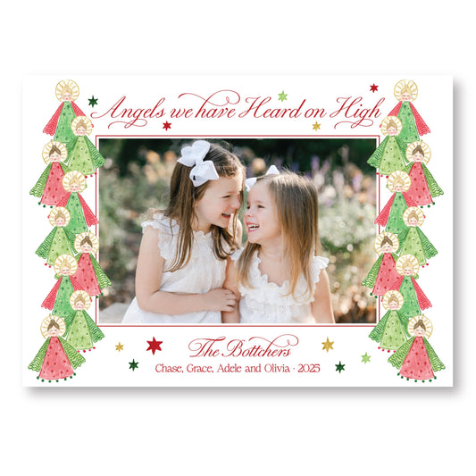 two young girls smiling and posing together in a festive frame with Christmas trees and stars.
